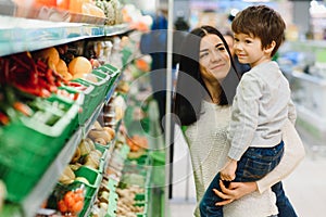 Mother and her son buying fruits at a farmers market