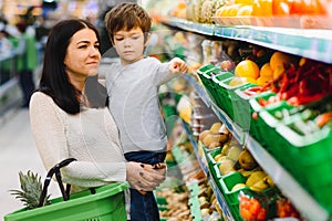 Mother and her son buying fruits at a farmers market