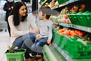 Mother and her son buying fruits at a farmers market