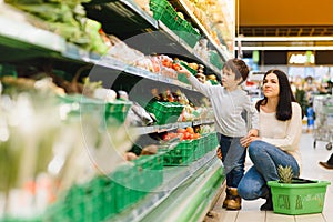 Mother and her son buying fruits at a farmers market