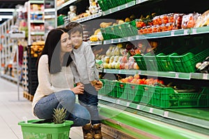 Mother and her son buying fruits at a farmers market