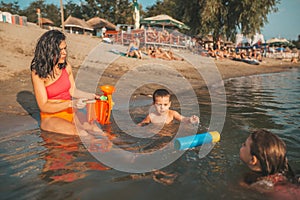 Mother, her son and daughter have fun in the water