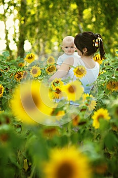 Mother with her son in the field with sunflowers