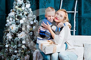 Mother and her son at home with a Christmas tree