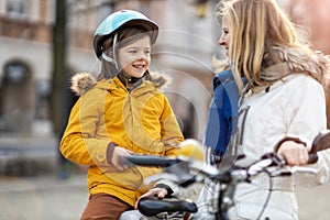 Mother and her son riding the bicycle in a city