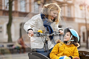 Mother and her son riding the bicycle in a city