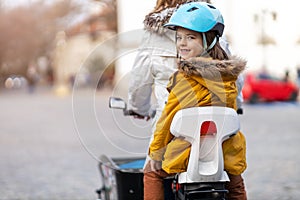 Mother and her son riding the bicycle in a city