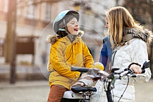 Mother and her son riding the bicycle in a city