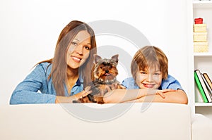Mother with her son and Yorkshire dog lay on sofa