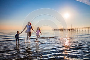 Mother and her sons jump on the sea