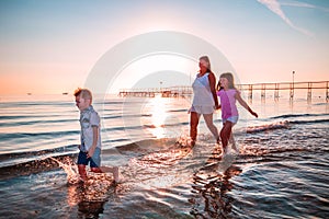 Mother with her sons playing on the shore