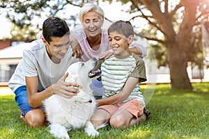 Mother and her sons playing with their dog