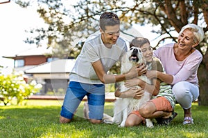 Mother and her sons playing with their dog