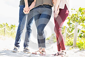 Mother and her teenage children holding hands.