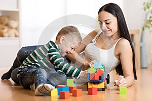 Mother and her toddler son plays with car in their living room