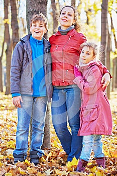 Mother and her two children stand having embraced