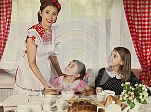 Mother with her two daughters have breakfast