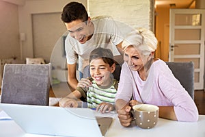 Mother with her two sons using laptop