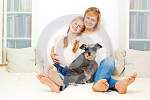 Mother with her 10 years old kid girl sitting home,