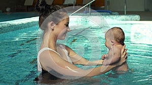 Mother hold baby in the pool
