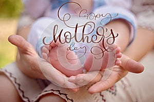 Mother hold the feet of her newborn son and Happy mothers day text. Calligraphy lettering hand draw