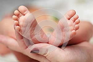 Mother hold feets of newborn baby