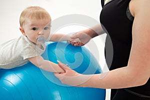 mother holding 5 month old baby balancing on yoga