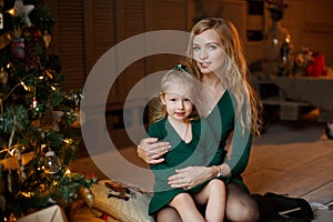 Mother holding adorable chubby little blonde girl little girl in