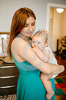 Mother Holding Baby Calming Her Newborn Child Mom Gently Soothing Infant. Five month old baby with blue eyes.