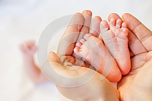 Mother holding baby feet at hands