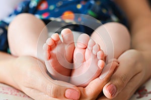 Mother holding baby feet in her palms