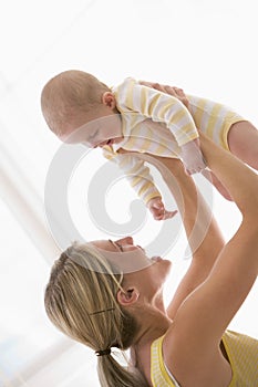 Mother holding baby indoors