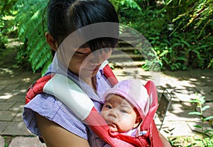 Mother holding baby in a park