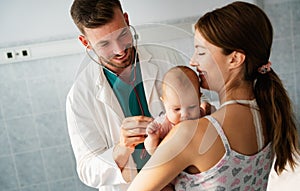 Mother holding baby for pediatrician doctor to examine