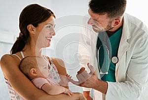 Mother holding baby for pediatrician doctor to examine