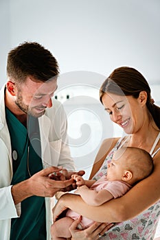 Mother holding baby for pediatrician doctor to examine