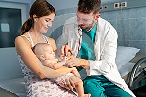 Mother holding baby for pediatrician doctor to examine