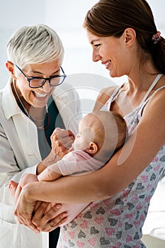 Mother holding baby for pediatrician doctor to examine