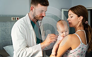 Mother holding baby for pediatrician doctor to examine