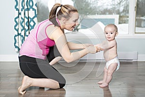 Mother holding a baby under his arms in living room