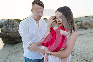 Mother holding cute baby girl outdoors on the beach