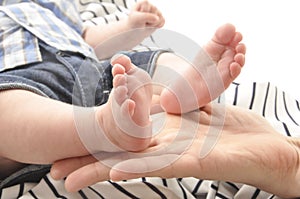 Mother holding a cute baby`s foot closeup