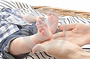 Mother holding a cute baby`s foot closeup white background