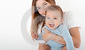 Mother holding cute happy baby boy with beautiful blue eyes on white background