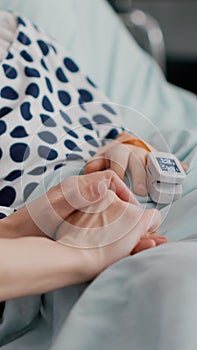 Mother holding daughter hands waiting for medication treatment after sickness infection