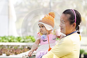 Mother holding daughter`s hand for a walk in the garden