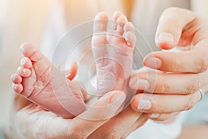 Mother holding feet of her newborn baby, parenting