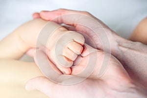 Mother holding the hand of a baby. Concept of empathy, trust, care and tenderness of motherhood