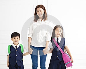 Mother holding hand of children ready go to school