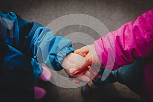 Mother holding hand of little daughter outdoors